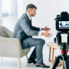 Interview mit einem Geschäftsmann wird durch eine Kamera aufgezeichnet