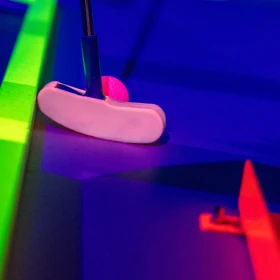 Schläger mit Golfball und Schwarzlichteffekten