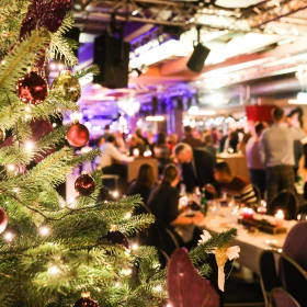 Weihnachtsfeier, Tannenbaum, Veranstaltungsraum, feiernde Menschen