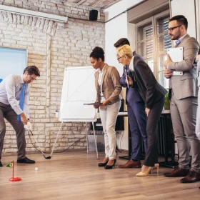 eine Gruppe im Büro beim Minigolfspielen