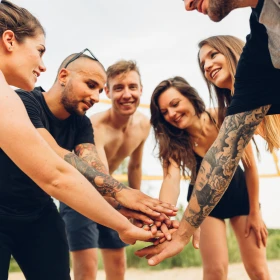 Gruppe animiert sich am Strand beim Volleyball