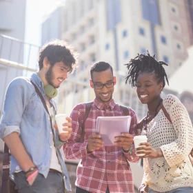 3 Personen schauen gemeinsam auf ein Tablet