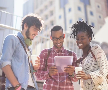 3 Personen schauen gemeinsam auf ein Tablet