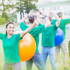 Personen versuchen gemeinsam einen Ball weiterzugeben