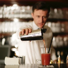 Barkeeper gießt rote Bloody Mary ein