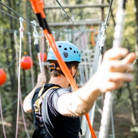 Mann im Kletterwald im Parcours