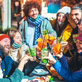 7 Personen sitzen als Gruppe und stoßen an