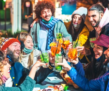 7 Personen sitzen als Gruppe und stoßen an