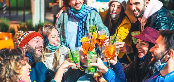 7 Personen sitzen als Gruppe und stoßen an