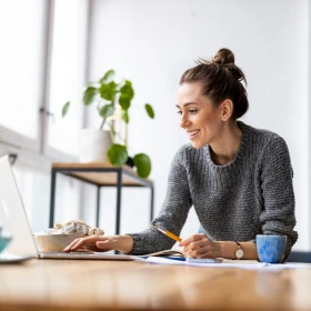 Frau sitzt an einem Laptop und arbeitet