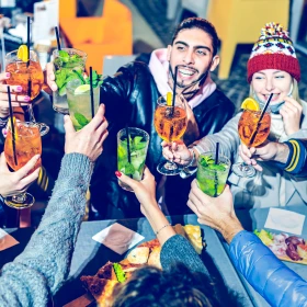 Gruppe stößt gemeinsam mit einem Cocktail an