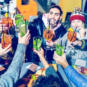 Gruppe stößt gemeinsam mit einem Cocktail an