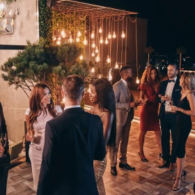 Businessleute feiern auf einer Terrasse bei Nacht