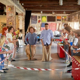 Menschen feuern 2 Teilnehmer beim Sackhüpfen an