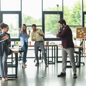 Gruppe spiel Golf in einem Büro