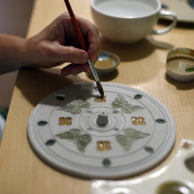 Keramik wird mit einem Pinsel per Hand bemalt