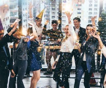 Businessmenschen feiern in einem Büro mit Sekt und Konfetti