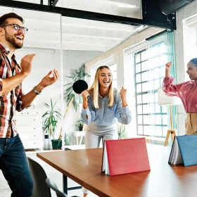 Tischtennis im Büro spiele mit Büchern als Netz auf einem Tisch