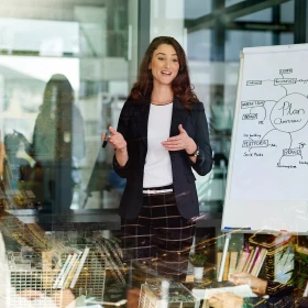 Frau erklärt etwas an einer Flipchart