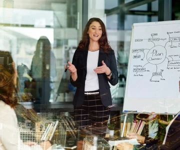 Frau erklärt etwas an einer Flipchart