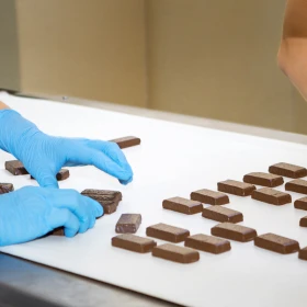 Person legt fertige Pralinen auf eine weiße Unterlage