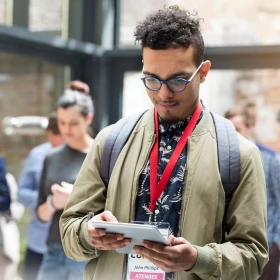 Man mit Tablet in der Hand, schaut auf das Tablet
