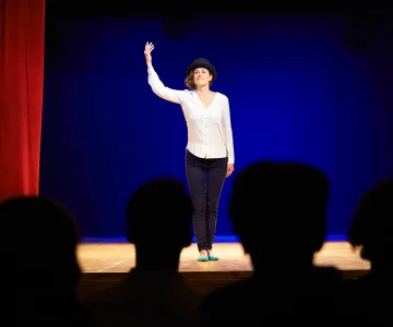 Frau führt eine Aufführung auf der Bühne vor
