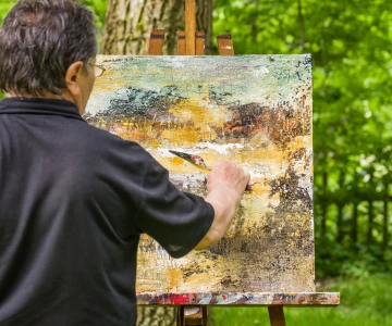 Mann malt ein Bild in der Natur