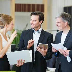 eine Frau und zwei Männer beim Smalltalk in der Pause