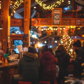 uhrige Hütte aus Holz mit Lichterketten, Personen sitzen an einer Bar