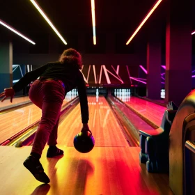 Person wirft Bowlingkugel nach hinten