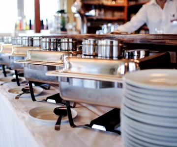 Buffet mit verschiedenen Chafings, geschlossen, Kellner im Hintergrund