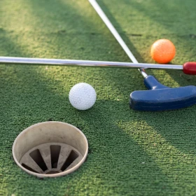 Golfschläger liegen überkreuz auf einem Rasen mit zwei Bällen