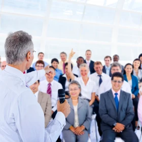 Person stellt eine Frage ins Publikum, eine Frau meldet sich