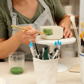 Frau malt ihre fertige Schale grün an