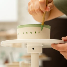 Person verziert ihr Kunwerk mit Farbe