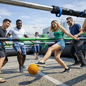Personen spielen Human Table Soccer auf dem Betriebsgelände