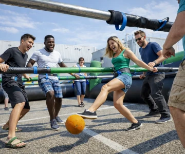 Personen spielen Human Table Soccer auf dem Betriebsgelände