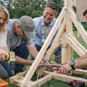 Männer bauen gemeinsam ein Katapult bei einem Teamevent
