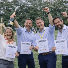 Siegerehrung, 4 Personen feiern mit Urkunden und Sekt