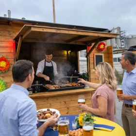 Grillstand, Marktfest, Menschen werden bedient, sommerliche Dekoration