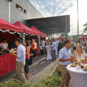 Sommerfest auf einem Firmengelände mit allen Mitarbeitern, rote Pavillons, Essen und Getränke