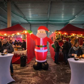 großer aufblasbarer Weihnachtsmann zwischen 2 roten Zelten