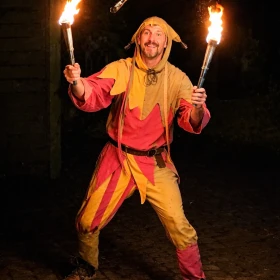 Gaukler jongliert mit drei Fackeln