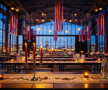 Eine stilvoll dekorierte Eventlocation im orientalischen Stil mit farbenfrohen Stoffbahnen, warmem Kerzenlicht und atmosphischer Beleuchtung. Die Kombination aus moderner Architektur und orientalischen Elementen schafft eine einzigartige Kulisse für eine exklusive Firmenfeier.