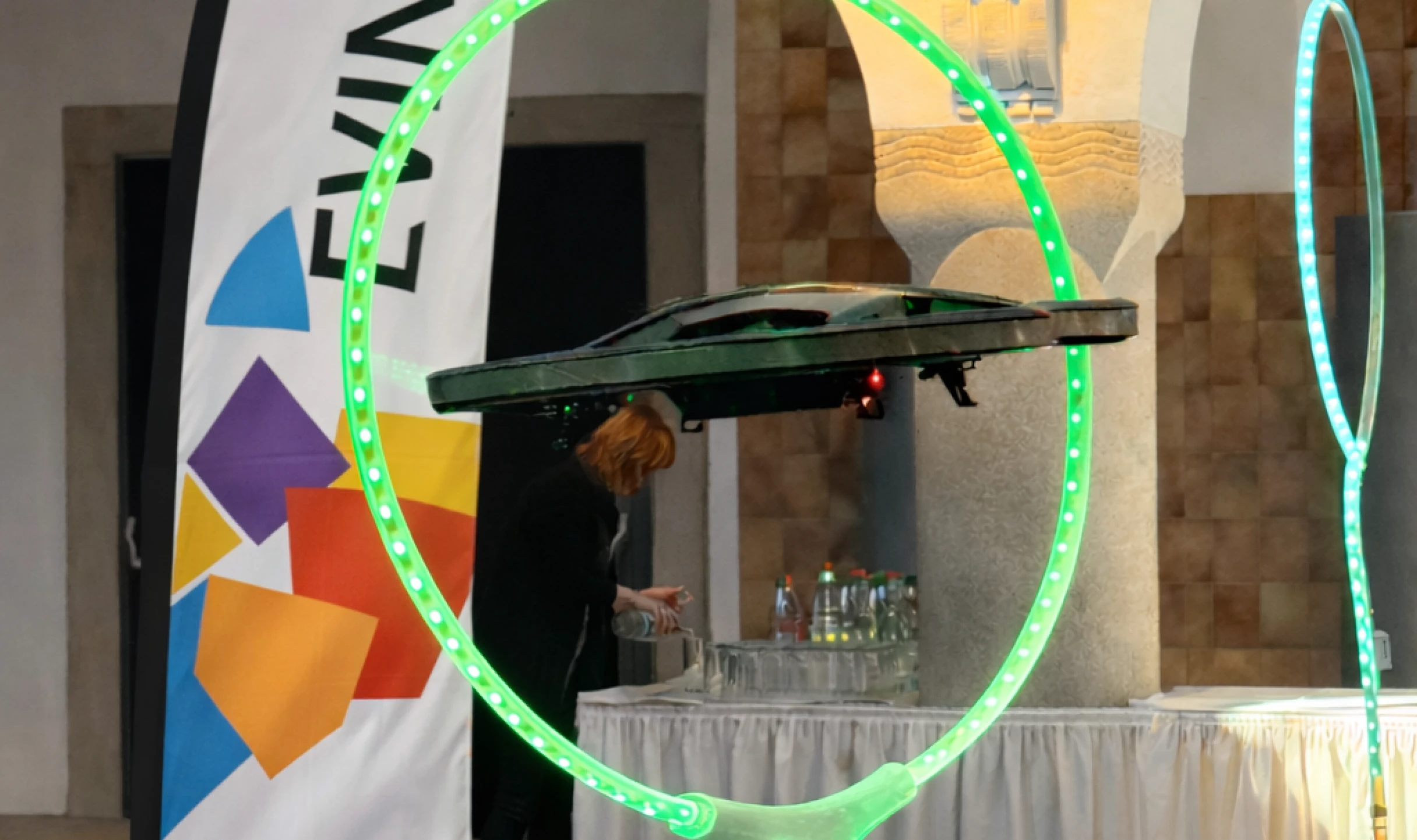 Drohne fliegt durch einen beleuchteten Reifen