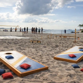 Cornhole und mehrere Spielstationen an einem Strand