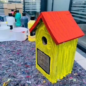 Vogelhaus gelb angemalt mit rotem Dach und Aufschrift "home sweet home"