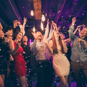 Personen tanzen und heben dabei die Arme