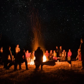 Menschen sitzen um ein Lagerfeuer